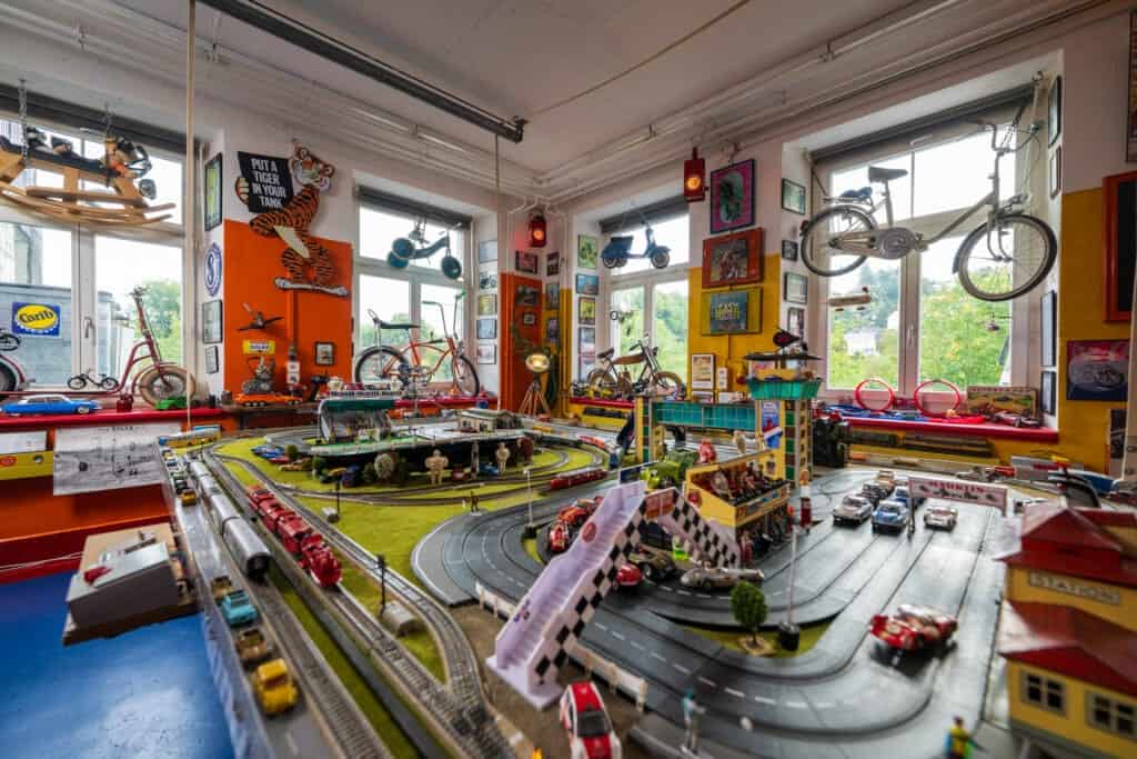 Bunte Miniaturauto-Sammlung in einer Spielzeuggarage mit Boombox-Level-Detail und Vintage-Charme.