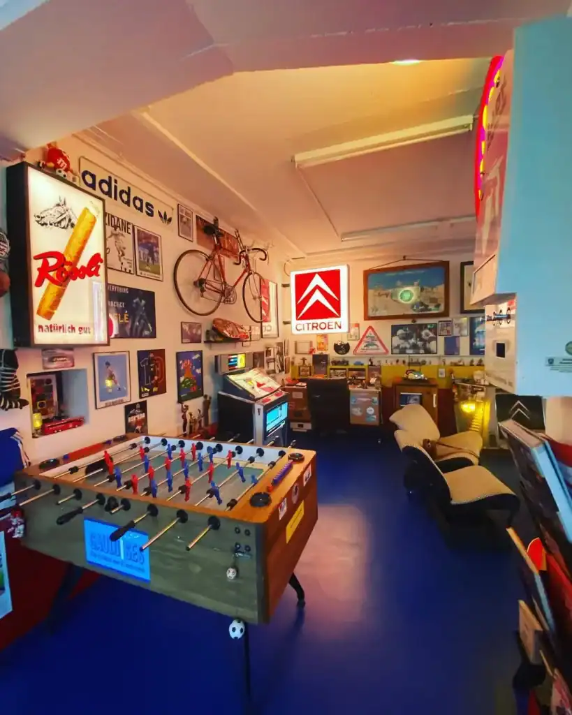 Vintage Spielraum mit Tischfussball, Oldtimer-Poster und Retro-Dekor.